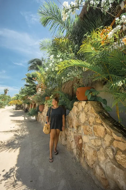 22+ Cheapest Countries To Backpack In The World! (2025) 24 tasha amy walking down a stone path near a palm tree in isla holbox