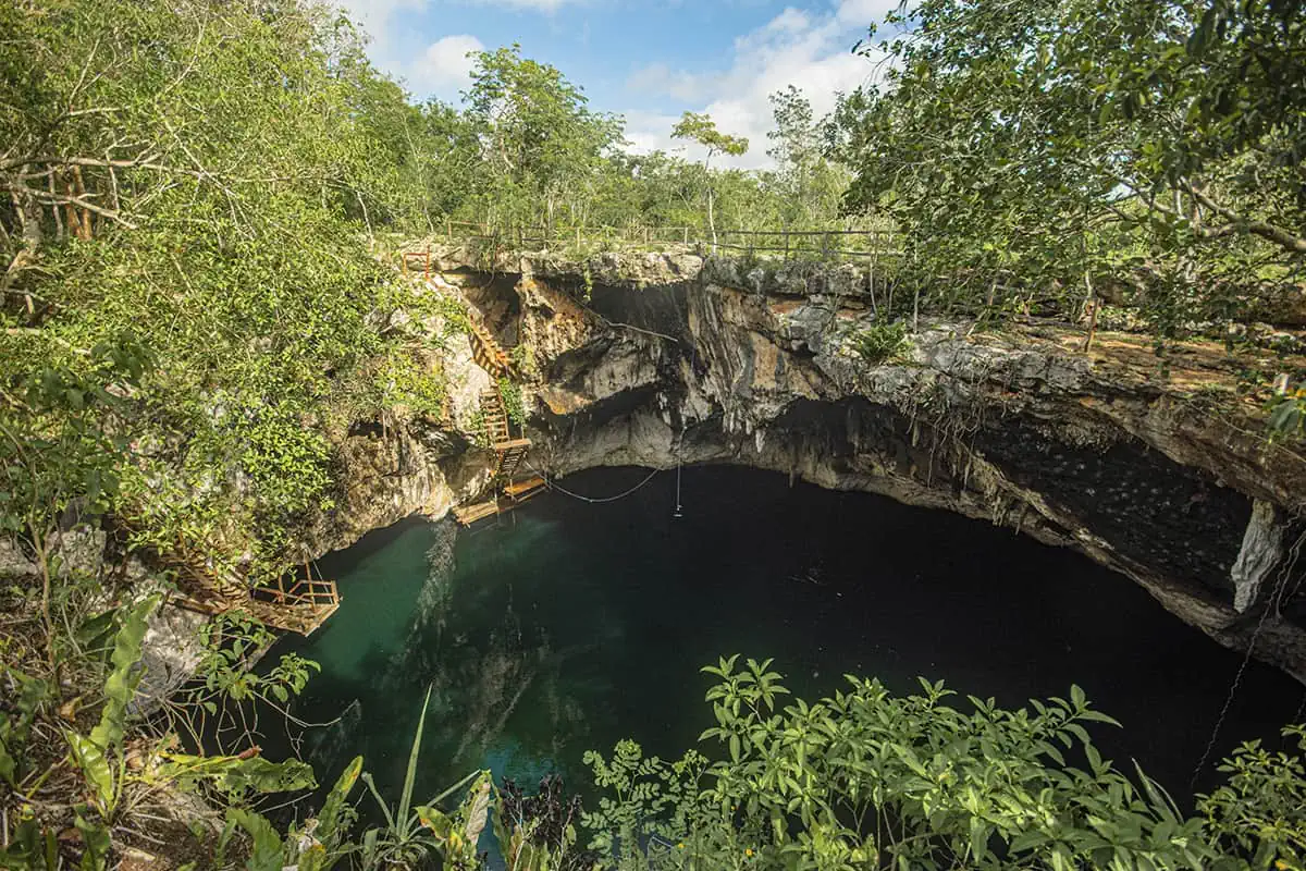 22+ Cheapest Countries To Backpack In The World! (2025) 26 A secluded cenote nestled within a lush jungle, surrounded by towering trees in mexico