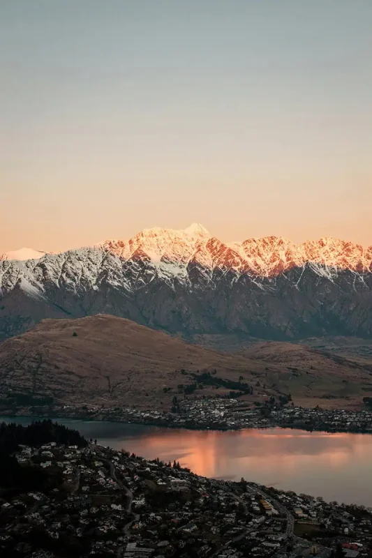 Fiordland & Milford Sound Lord Of The Rings Locations (2025) 18 Snowy peaks glow pink under the sunset in Queenstown, New Zealand