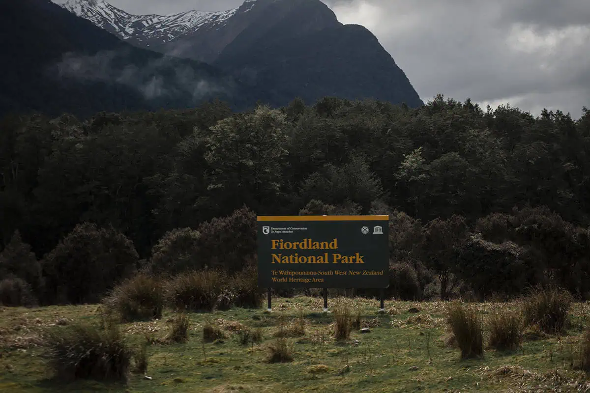 Fiordland & Milford Sound Lord Of The Rings Locations (2025) 16 A dark green sign marks the entrance to Fiordland National Park in New Zealand, a Lord of the Rings filming location