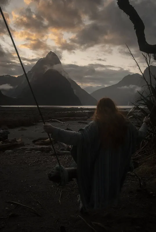 Milford Sound Swing: Where To Find It (2025) 4 tasha amy gripping the ropes of the handmade Milford Sound swing, looking out over the fjord and dramatic sky.