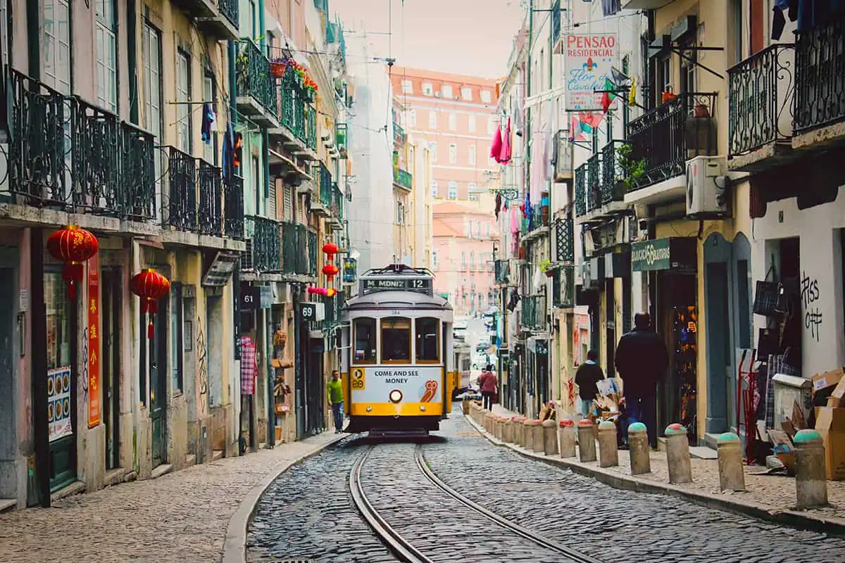 22+ Cheapest Countries To Backpack In The World! (2025) 29 A tram traveling down a narrow street in backpacker-friendly Lisbon.