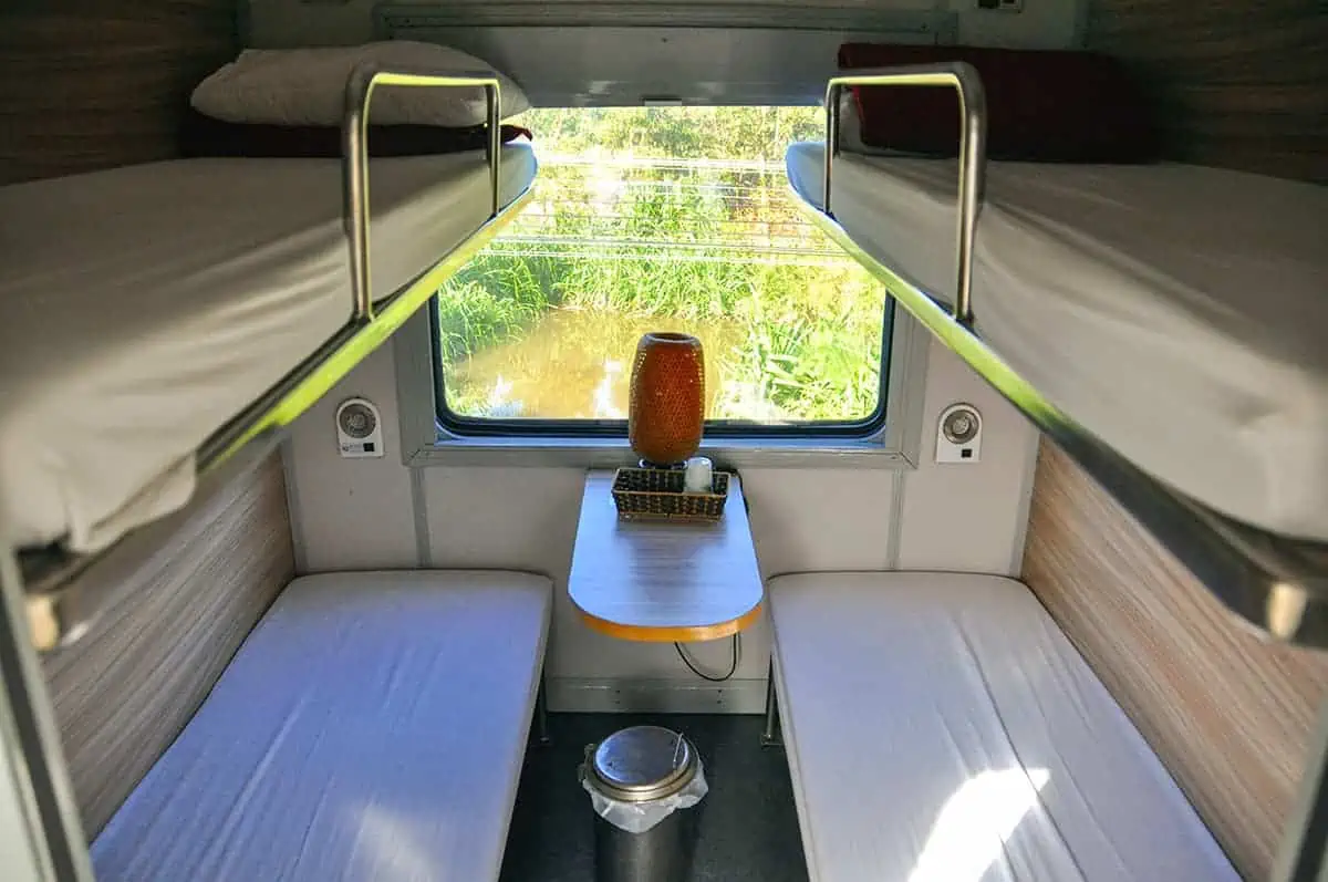 Vietnam Sleeper Train Ultimate Guide For Tourists (2025) 9 A cozy first class sleeper cabin on a Vietnam train, featuring bunk beds and a window view, providing comfort for nighttime travel.