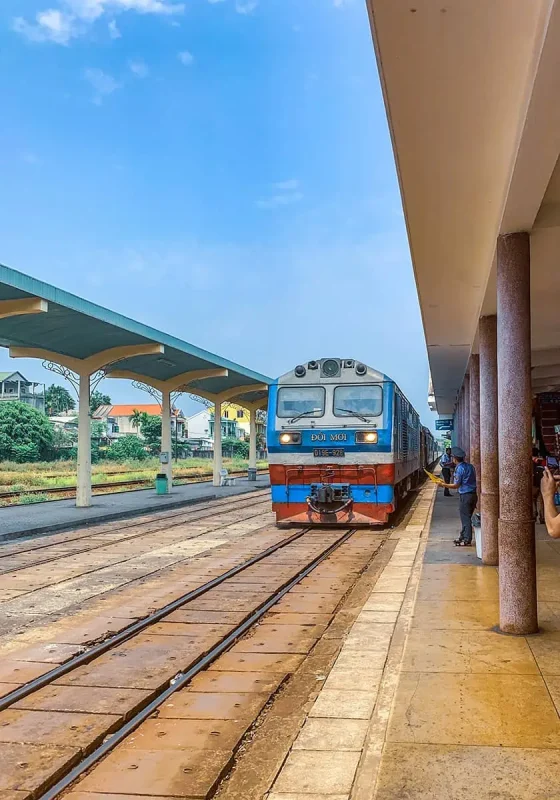 Vietnam Sleeper Train Ultimate Guide For Tourists (2025) 11 The blue and orange sleeper train ready for an overnight journey, docked at a station with clear skies above
