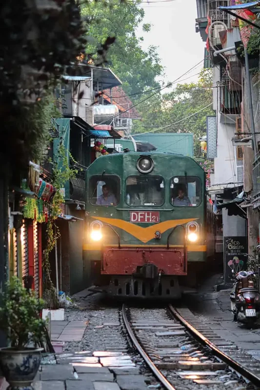 Vietnam Sleeper Train Ultimate Guide For Tourists (2025) 4 Sleeper train passing through a tight urban alley in Hanoi