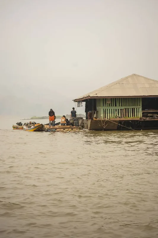 Taking The Slow Boat To Luang Prabang: BEST Tips 2025 19 A floating market by the Mekong River with locals on boats engaging in daily trade.