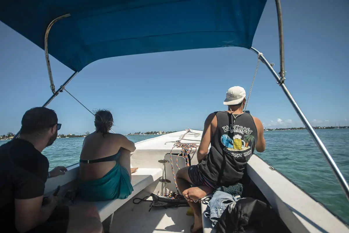 Caye Caulker Snorkeling Tours: Discover The Ultimate Underwater Paradise 14 three backpackers sitting on the front of a boat on a caye caulker snorkeling tour