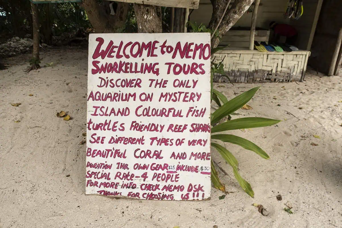 Things To Do On Mystery Island In Vanuatu: For Cruise Passengers & More 19 A hand-painted sign in the sand advertises Nemo Snorkelling Tours which is one of the best things to do on Mystery Island, inviting visitors to explore coral reefs, colorful fish, and friendly reef sharks.