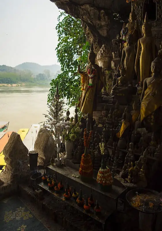 3 Days In Luang Prabang Itinerary: ULTIMATE Guide 9 decorative buddhas in pak ou caves looking out to the mekong river