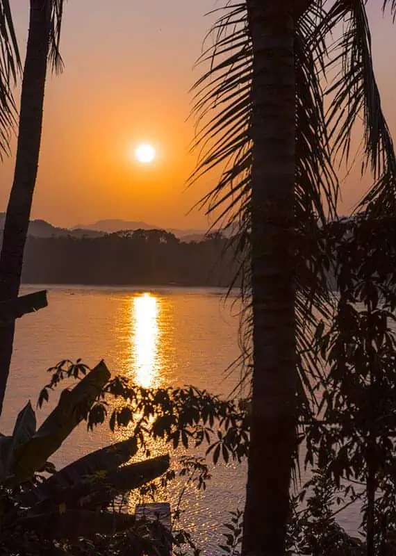 3 Days In Luang Prabang Itinerary: ULTIMATE Guide 29 sunset through the trees over the mekong river, the ideal way to spend an evening on the 3 days in luang prabang itinerary
