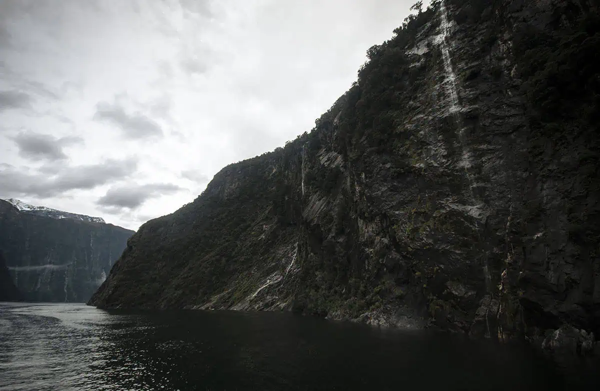 Best Waterfalls In Milford Sound Worth Checking Out 2 A part of the four sisters waterfall cascades down a steep cliffside into the still water, one of the best waterfalls in milford sound