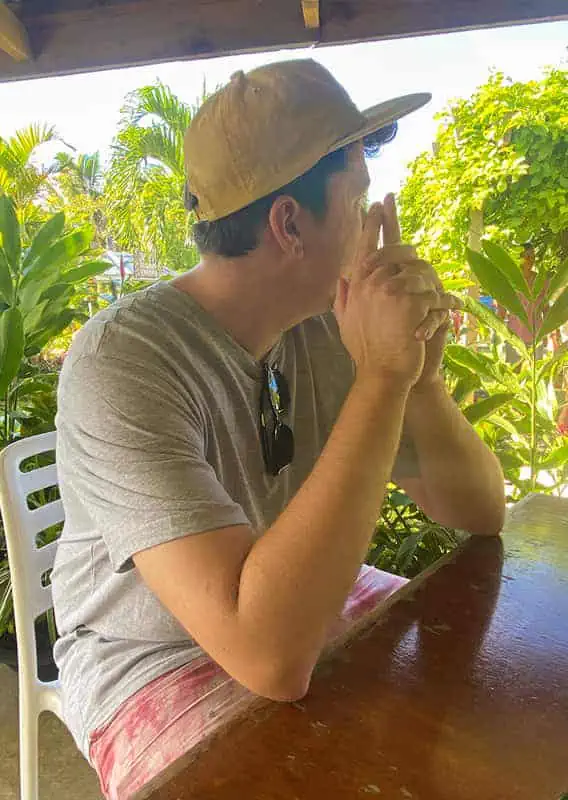 Where To Eat In Rarotonga: BEST Restaurants & Cafes 2025 4 A man in a casual outfit sitting thoughtfully at LBV, embodying the relaxed dining atmosphere of the island.