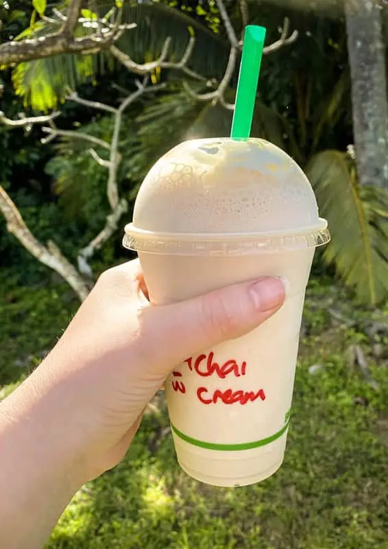 Where To Eat In Rarotonga: BEST Restaurants & Cafes 2025 12 A hand holding a creamy, chilled chai with whipped cream, a popular refreshment found at Love Cafe.