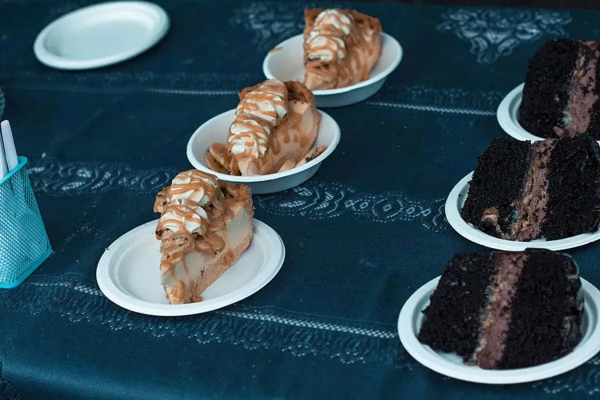 Where To Eat In Rarotonga: BEST Restaurants & Cafes 2025 22 Slices of caramel drizzle cheesecake and rich chocolate cake served on white plates, a sweet treat from the Muri Beach Night Market, a popular dinner spot in Rarotonga.