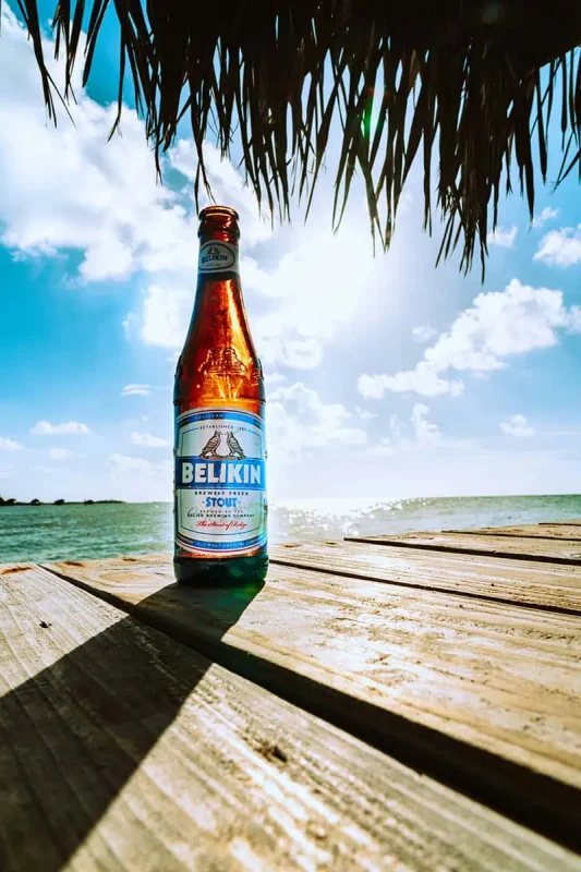 Why Visit Belize: 20 Reasons To Add It To Your Travel Bucketlist 26 a delicious local belikin beer on the beach in belize